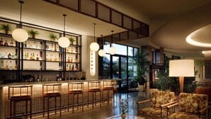 A bar area with stools, a sofa, and a coffee table. - The Ava Hotel Paso Robles, Curio Collection By Hilton (Paso Robles)