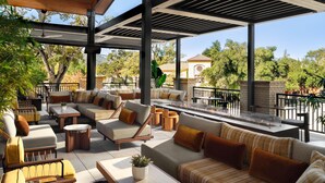 An outdoor patio area with multiple seating options, including sofas and chairs, arranged around a central fire feature. - The Ava Hotel Paso Robles, Curio Collection By Hilton (Paso Robles)