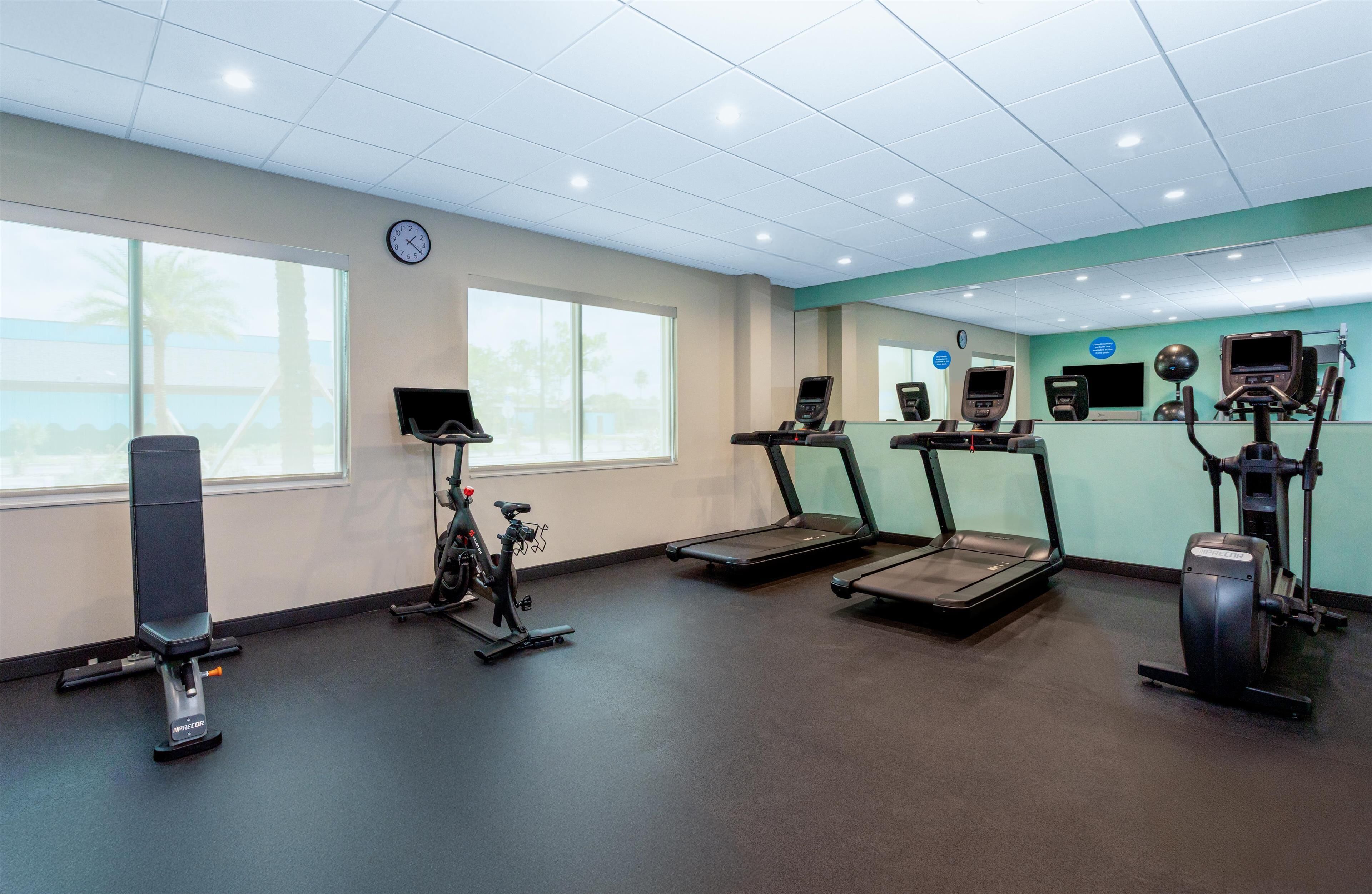 A gym with treadmills, an elliptical, and a stationary bike.
