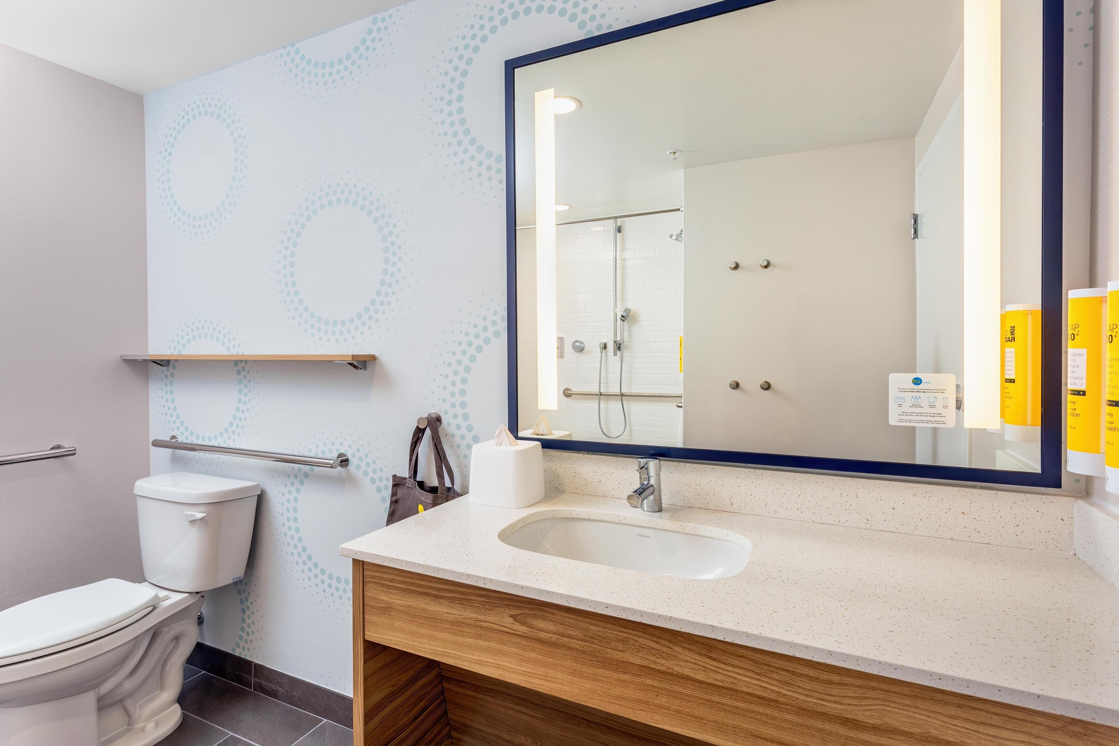 Un bagno moderno con il water, un lavandino e uno specchio.