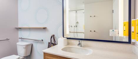 Ein modernes Badezimmer mit Toilette, Waschbecken und Spiegel.