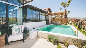A modern house with a swimming pool, large windows, and outdoor seating.