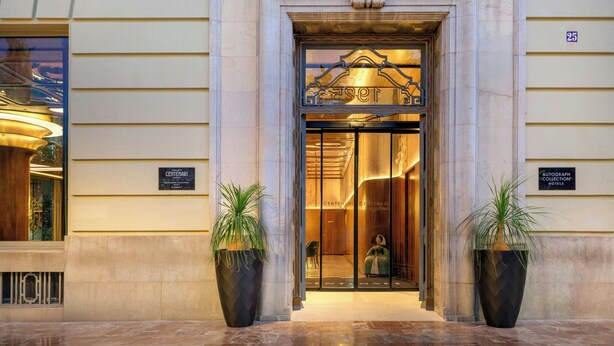 A hotel entrance with a grand archway, a sign reading "CENTENARI," and two large potted plants. - Grand Hotel Centenari, Valencia, Autograph Collection (Valencia)