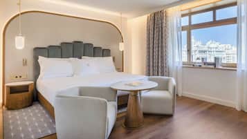 Sengetøy av topp kvalitet, dundyner, minibar og safe på rommet