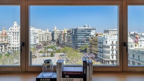 A view from a window with books on a table, overlooking a cityscape with historic buildings and a clear sky. - Grand Hotel Centenari, Valencia, Autograph Collection (Valencia)