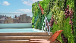 A rooftop pool area with a green wall and a lounge chair. - Grand Hotel Centenari, Valencia, Autograph Collection (Valencia)
