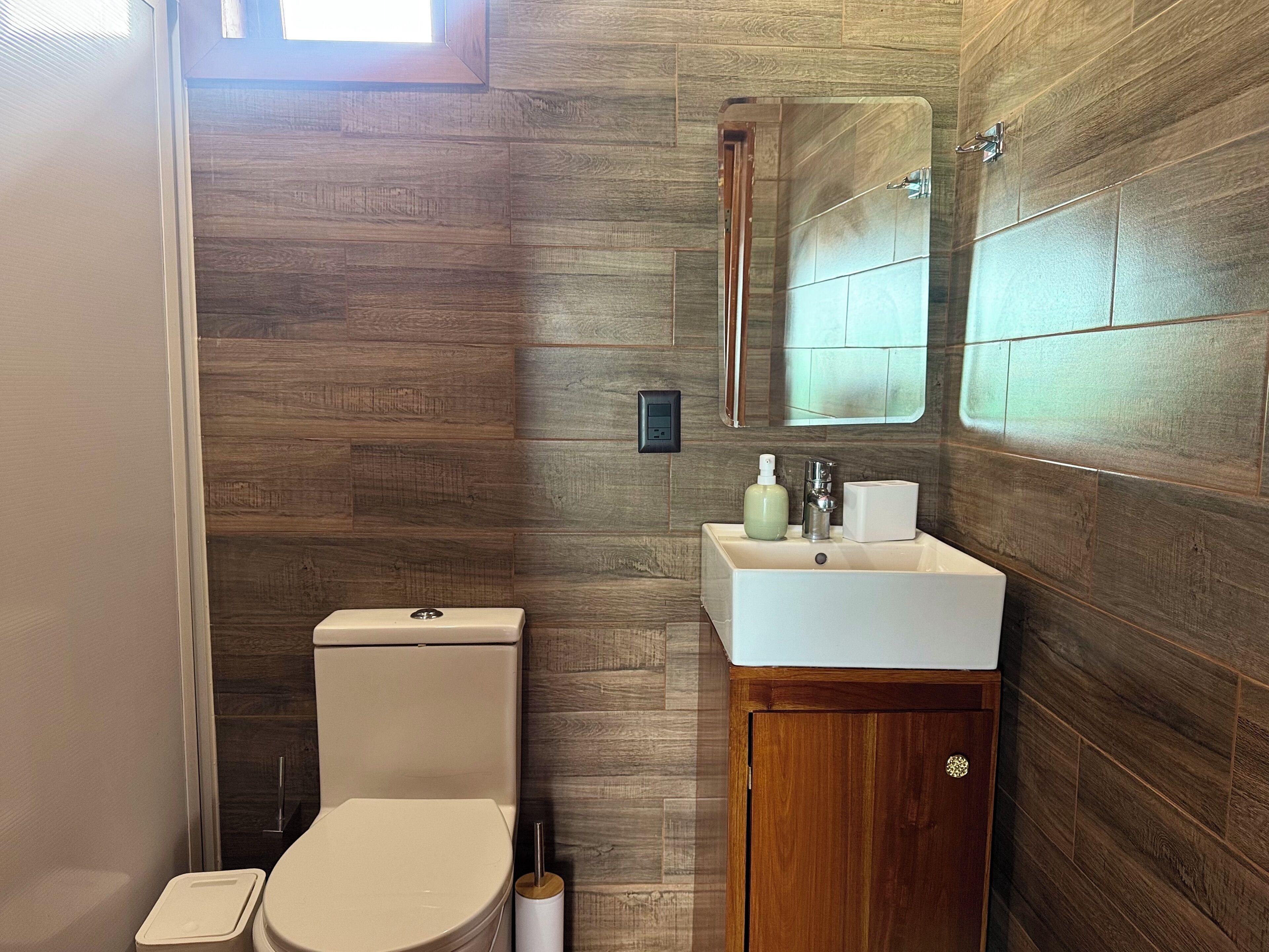 Ein Badezimmer mit Toilette, Waschbecken und Spiegel.