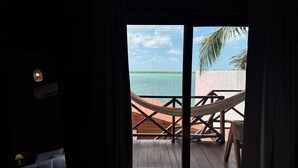 Une chambre avec vue sur l’océan, un hamac et un lit.