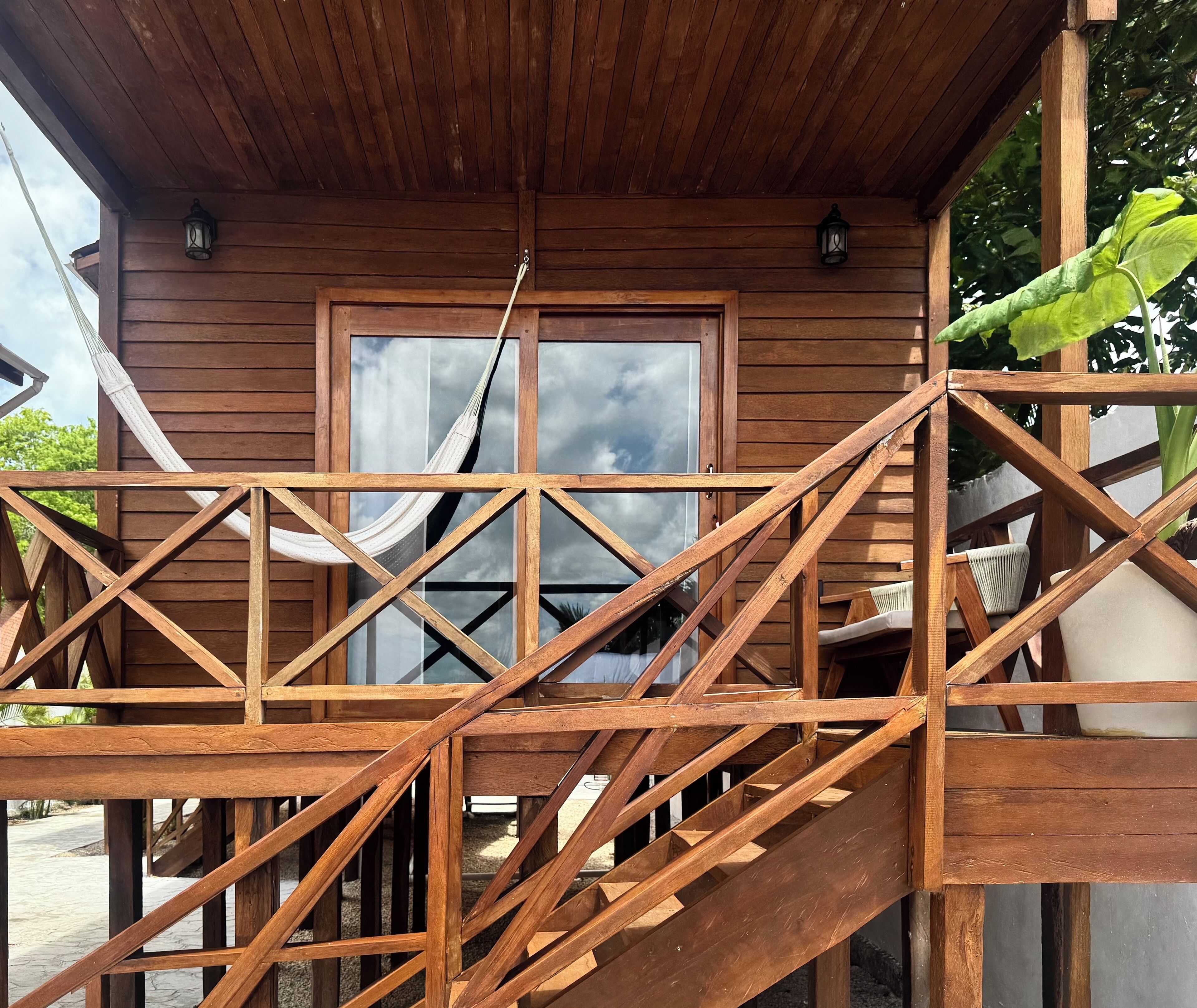Une structure en bois dotée d’une fenêtre et d’un hamac.