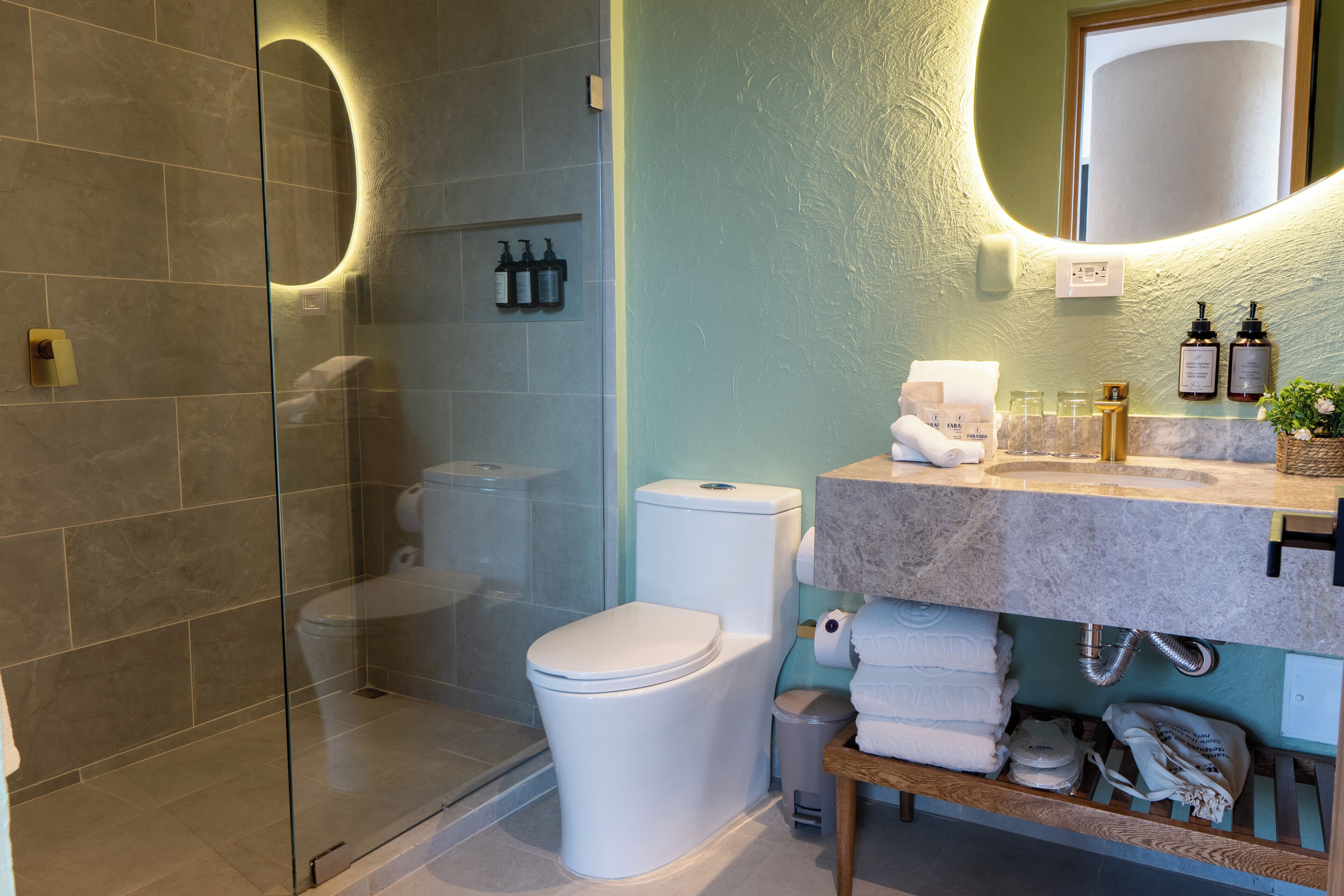 A modern bathroom with a glass-enclosed shower, a toilet, and a vanity with a mirror.