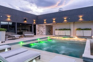 Una piscina al aire libre, sillones reclinables de piscina