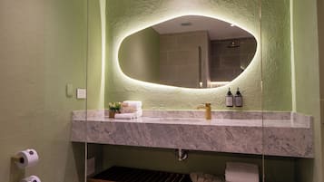 A bathroom with a marble sink, a large mirror, and a towel rack.