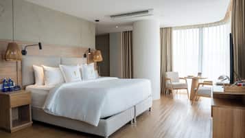 Une chambre d’hôtel moderne avec un grand lit, un bureau et une chaise.