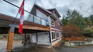 Ein zweistöckiges Haus mit Garage, Balkon und einer Flagge.