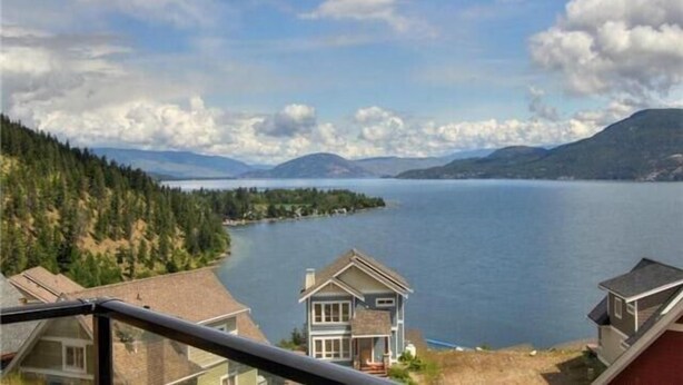 A house with a view of a lake and mountains.