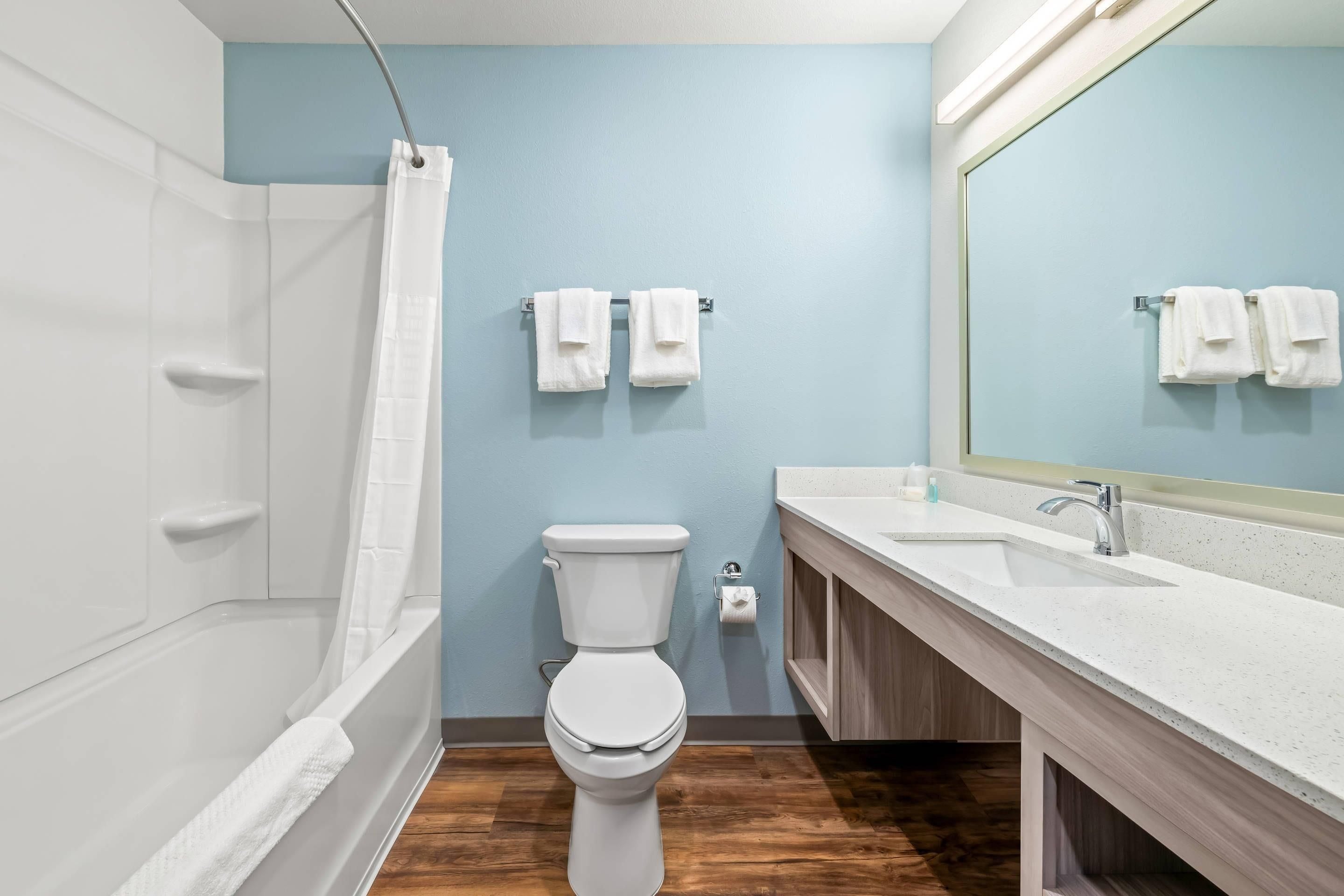 A modern bathroom with a bathtub, toilet, and sink.