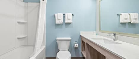 A modern bathroom with a bathtub, toilet, and sink.