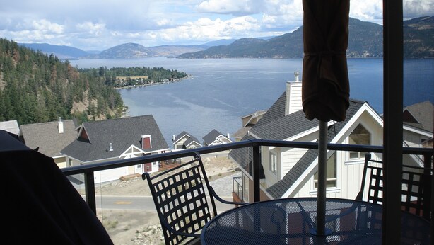 A balcony with a view of a lake and mountains.