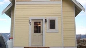 A two-story house with a front door, a small window above the door, and a larger window on the second floor.