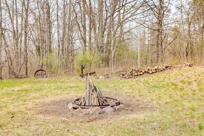 Relax by the fire pit in a serene natural setting surrounded by trees.