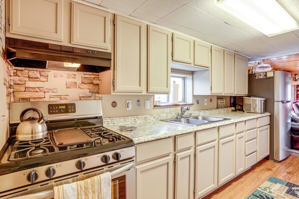 Enjoy cooking in this well-equipped kitchen with a central stove, oven, and sink, plus a microwave and refrigerator.