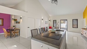 A spacious kitchen with a central island, a dining area with chairs, and a kitchen counter. - Villa Troupial- Jan Thiel (Jan Thiel)