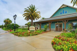 A building with a sign reading "Riversend Recreation" and a covered walkway with flower beds.