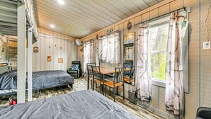 A room with bunk beds, a dining table, chairs, and a window with curtains. - Secluded on 10 Acres: Livingston Getaway w/ Sauna! (Livingston)