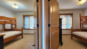 A room with bunk beds, a door, and windows with blinds. - Charming 2 Bed  and  Loft Cottage at La Casa Lakeside Resort (Kelowna)