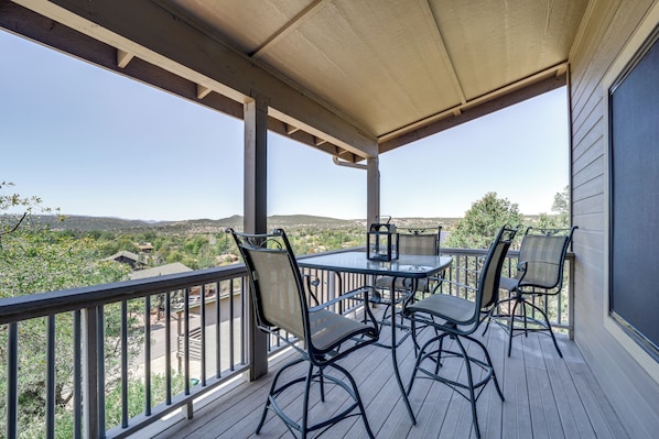 A covered outdoor patio with a table and chairs, overlooking a scenic landscape. - Stunning Mountain Views: Peaceful Payson Retreat! (Payson)