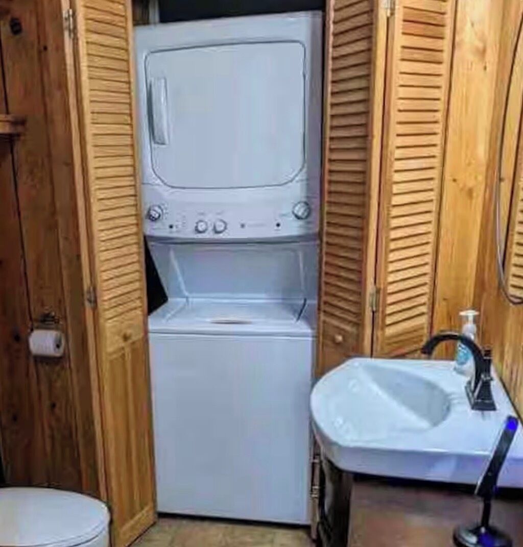 A compact laundry room with a washing machine and a sink.