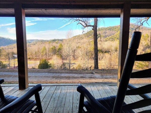 A wooden deck with a view of a forested landscape.