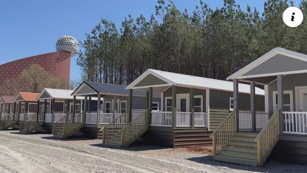 A row of mobile homes with front porches and steps, set against a backdrop of trees and a large spherical structure. - Tiny Homes for Rent, minutes to the Casino, Golf Course & Water Park (Philadelphia)