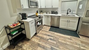 A modern kitchen with white cabinets, stainless steel appliances, and a wooden floor. - The Cardinal. Newly built 1-bedroom cottage w/ WiFi and AC in delightful Muncie (Muncie)