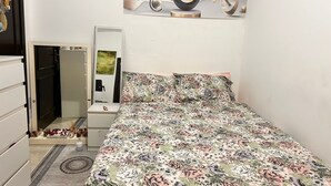 Ein Schlafzimmer mit einem Bett, einem Schminktisch, einem Spiegel und einem Wandbild.