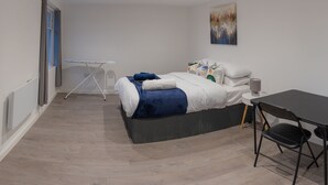 Une chambre à coucher moderne avec un lit, un bureau et une chaise.