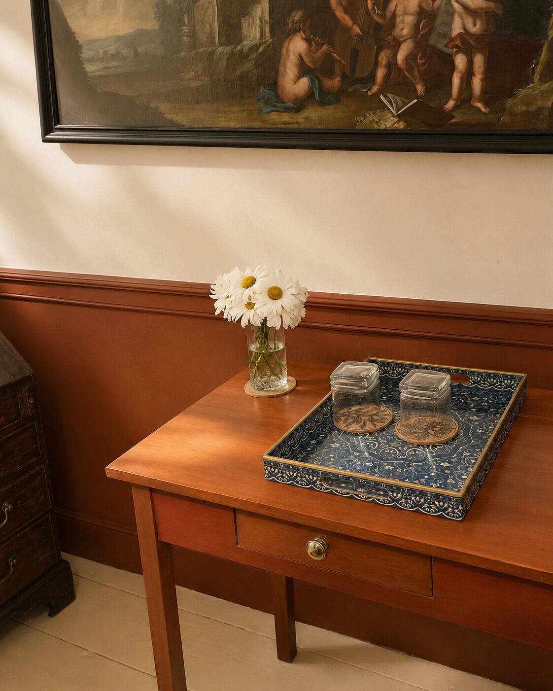 Une table en bois, sur laquelle se trouve un vase rempli de fleurs blanches et un plateau contenant des récipients transparents.
