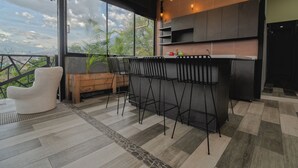 Una cocina moderna con barra, ventanas amplias y vistas a zonas verdes.
