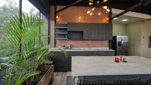 Una cocina moderna con una isla grande, electrodomésticos integrados y un comedor con sillas.