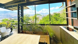 Un balcón con vista a un paisaje urbano y montañas.