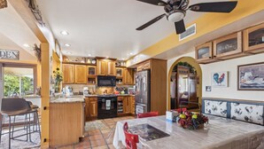 A kitchen with wooden cabinets, a refrigerator, and a dining area with a table and chairs. - Mesa Meadow Retreat (Mesa)