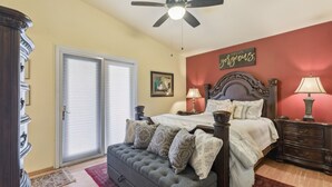 A bedroom with a bed, a ceiling fan, a nightstand, a dresser, and a door. - Mesa Meadow Retreat (Mesa)