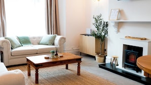 Un salon avec un canapé, une table basse et une cheminée.