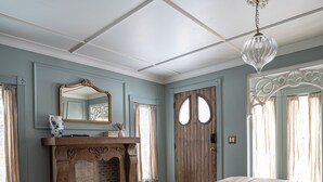 Ein Zimmer mit einem Holztisch, einem Kamin und einer Kristallleuchter.