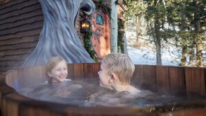 Ein Whirlpool mit Holzinnenraum und einer Baumdekor an der Wand.