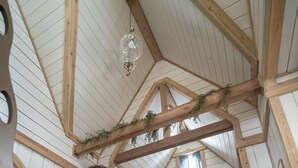 Ein gemütliches Schlafzimmer im Dachgeschoss mit einer Holzleiter, einem Kamin und einem Etagenbett.