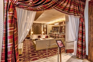 A hotel lobby with a seating area, a bar, and a view of the bar area. - Virginia Beach | Coastal Getaway | Resort Pool & Beach Access (Virginia Beach)