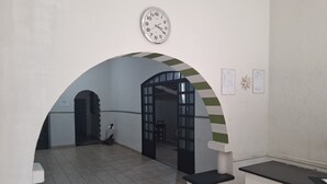Ein Innenbereich, ein Korridor mit einer Uhr, einem Bogen und einem Empfangstresen.