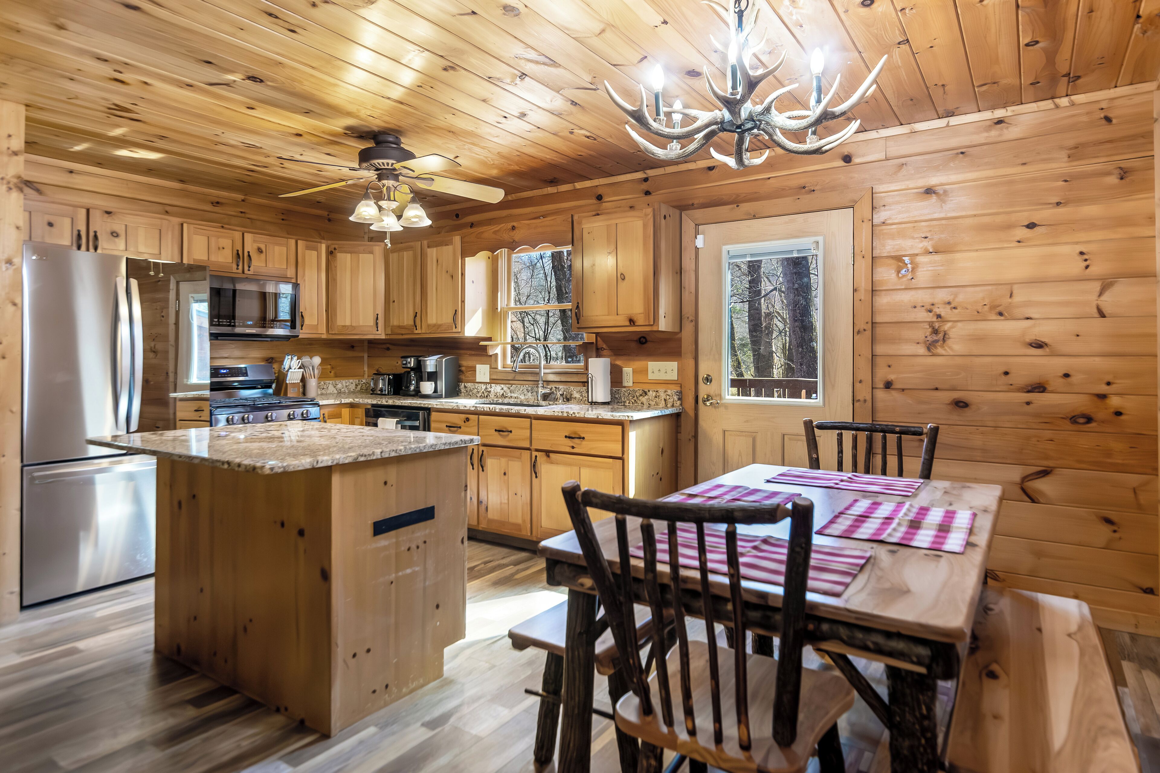L’intérieur d’une cabane en bois comprend un coin cuisine, une table à manger et des chaises.