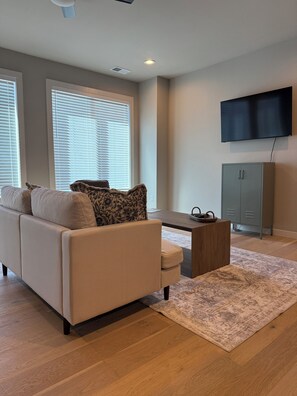 Relax in this stylish living room with a beige sofa, coffee table, and flat-screen TV.